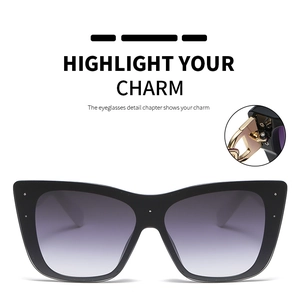 Detail of golden metal hinge and silver stud accents on black cat eye sunglasses