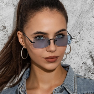 Close-up of stylish rectangle frameless blue sunglasses on model with hoop earrings