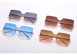 Flat lay of oversized rimless square sunglasses with gradient lenses and gold rivet details