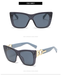 Detail of grey cat-eye sunglasses with blue temples and gold chain metal link accents