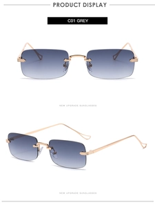 Detailed macro of rimless rectangular sunglasses with grey lenses and gold metal frames