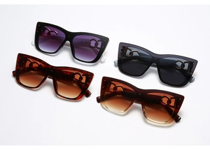 Macro detail of cat-eye sunglasses featuring stylish metal chain link hinge design