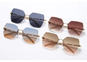 Detail of oversized rimless sunglasses featuring geometric lenses and top metal chain decor
