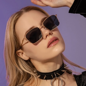 Retro small square metal sunglasses with gold frame and black lenses on model