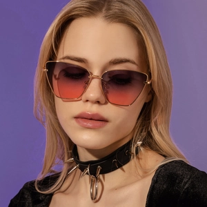 Nahaufnahme der Cat-Eye-Sonnenbrille mit goldener Metallfassung und lila Verlaufsgläsern