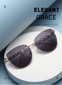 Détail des verres dégradés violets et branches à chaîne dorée de lunettes élégantes