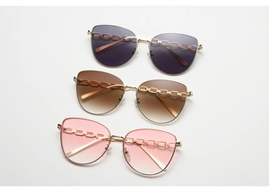 Détail de lunettes de soleil œil de chat avec chaîne dorée et verres dégradés en trois tons