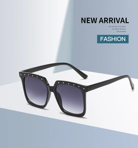 Detail of square oversized sunglasses with punk metal rivets and gradient purple lenses