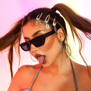 Close-up of Y2K style silver butterfly hair clips and black rectangular sunglasses