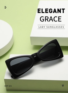 Close-up of black geometric cat-eye sunglasses on elegant props with soft lighting