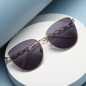 Lunettes de soleil œil-de-chat avec monture dorée et verres violets à détails de chaîne