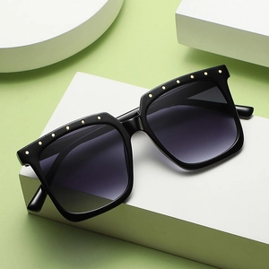 Square oversized sunglasses with black frames, gold rivets, and gradient grey lenses