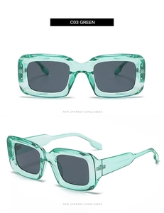 Detailed view of square green sunglasses with transparent frame and dark gray lenses