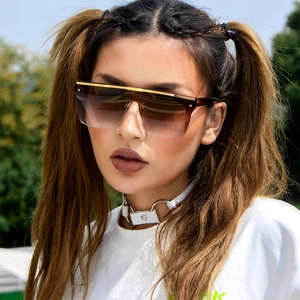 Détail de lunettes de soleil carrées avec barre dorée et verres dégradés sur modèle