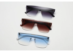Détail de trois lunettes de soleil bouclier avec verres dégradés et rivets métalliques