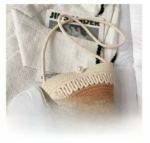 Close-up of woven bucket bag with large pearl button closure and a phone for size comparison
