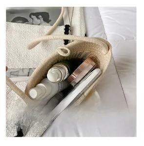 Interior view of beige woven bucket bag showing capacity for cosmetics and pearl detail