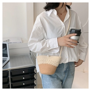Detail of hand-woven crossbody bag with bicolor cotton pattern and pearl buckle closure