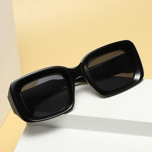 Classic black rectangular sunglasses with UV400 protection on a white geometric stand