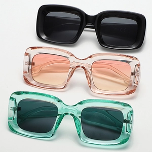 Three pairs of vintage square oversized sunglasses in black, pink, and green frames