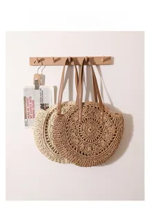 Sacs ronds en paille de style français beige et marron avec anses en cuir sur un support