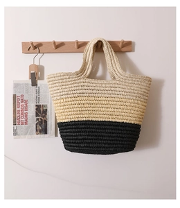 Detail of hand-woven straw tote bag with white, yellow, and black striped fiber texture