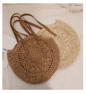 Détail de sacs ronds en paille tressée avec bandoulières en cuir marron et beige
