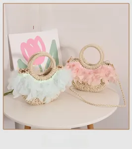 Détail de sacs en paille artisanaux avec garniture en plumes et anses rondes pour la plage