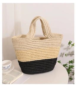 Detail of handwoven straw tote featuring a minimalist natural and black color-block design