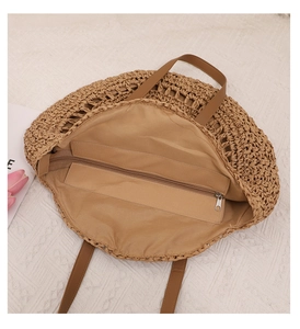 Vue interne du sac en paille montrant la doublure et la poche zippée en métal sécurisée