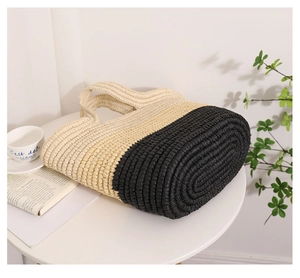 Close-up of large striped straw tote bag showing detailed weave texture and oval base