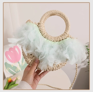 Détail d'un sac en paille tissé à la main avec plumes vert menthe et poignée ronde