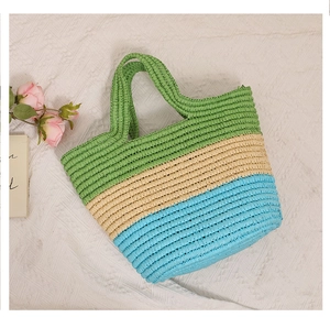 Detail view of woven tote bag with tricolor stripes in green, beige and blue for beach