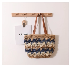 Close-up of woven straw tote bag with wave patterns and brown leather shoulder straps