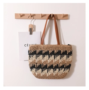 Detailed view of large straw tote featuring contrast wave pattern and brown leather straps
