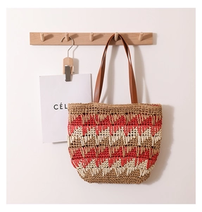 Detailed view of the wavy three-color weave pattern on a large straw shoulder tote bag