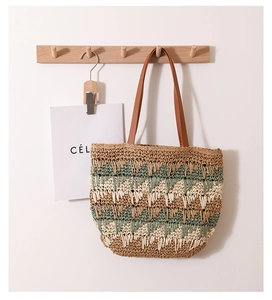 Detail of hand-woven straw bag showing wave pattern and brown leather handle texture