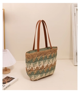 Close-up of wavy pattern woven straw tote bag with brown leather straps in a home setting
