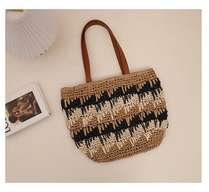Macro view of woven straw beach bag with contrast stripes and durable leather handles