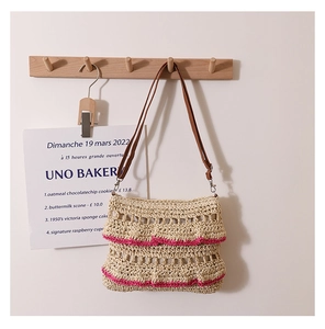 Détails d'un sac en paille tissé main avec volants rose fuchsia et bandoulière en cuir