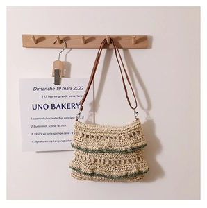 Détail d'un sac en paille beige tissé main avec volants et fine bandoulière en cuir