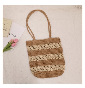 Close-up of hollow floral crochet texture and striped straw bag for beach vacation