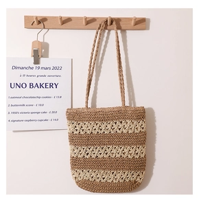 Detail of hollow lace weaving on a striped straw tote bag for summer beach vacations