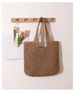 Detailed view of hand-woven straw tote bag with wide straps for shoulder carry