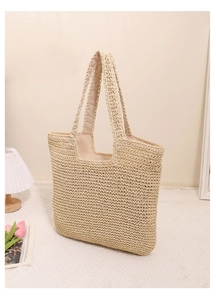 Detail of hand-woven straw tote bag with fine texture and durable braided handles