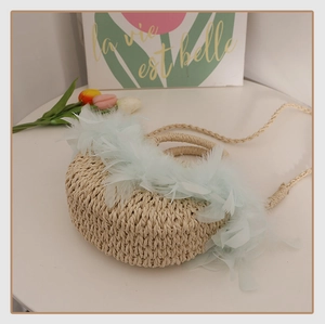 Sac bandoulière demi-rond en paille tressée avec plumes vert clair pour vacances à la mer