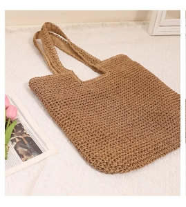 Macro detail of brown woven straw tote bag with textured handmade crochet pattern