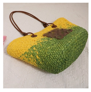 Détail du sac cabas tissé coloré avec rayures jaune-vert et anses en cuir marron