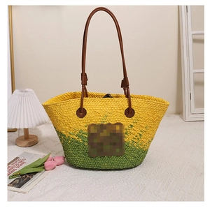 Détail du sac cabas en paille tissée avec dégradé jaune-vert et anses en cuir brun