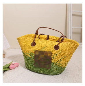 Détail du sac cabas tissé bicolore jaune et vert avec poignées en cuir marron